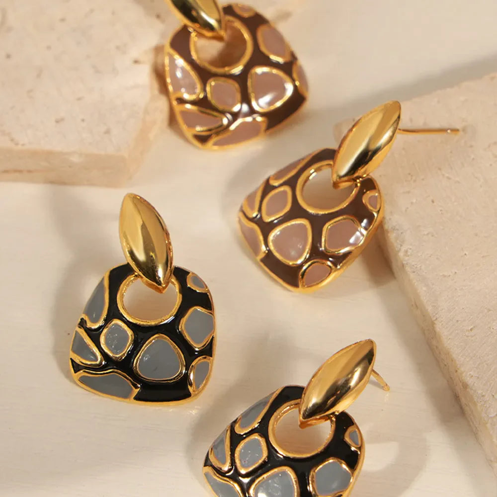 Geometric enamel drop earrings in black and brown with gold accents.