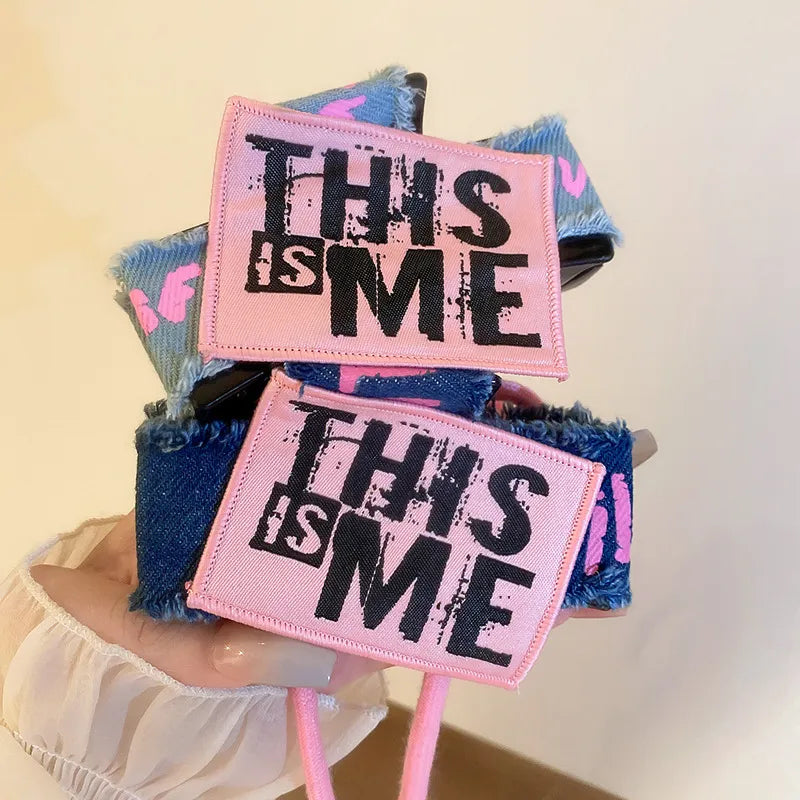 Denim patchwork claw clip with pink "THIS IS ME" patches and drawcord.