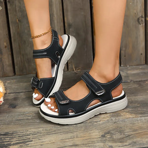 Black platform sandals with white contrast stitching and adjustable straps.