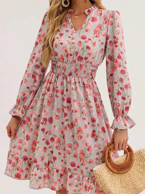Romantic floral smocked dress in blush pink with ruffled cuffs and hem.