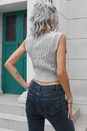 Gray cropped cable knit vest with V-neck and sleeveless design.