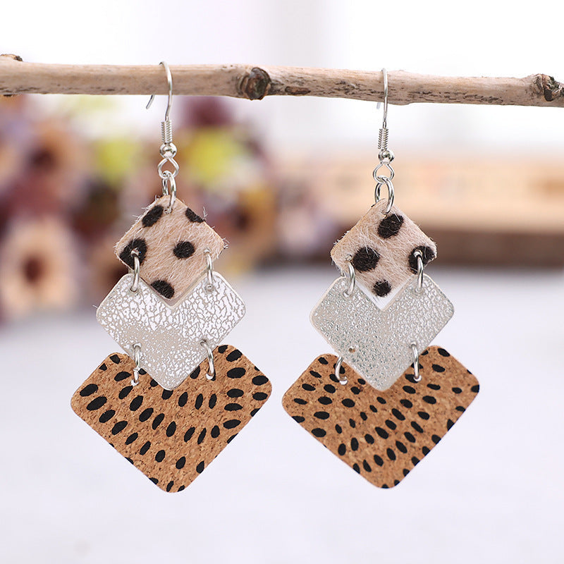 Textured leopard print drop earrings with silver diamond shapes.