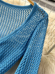 Blue crochet knit tied crop top with V-neck and long sleeves.