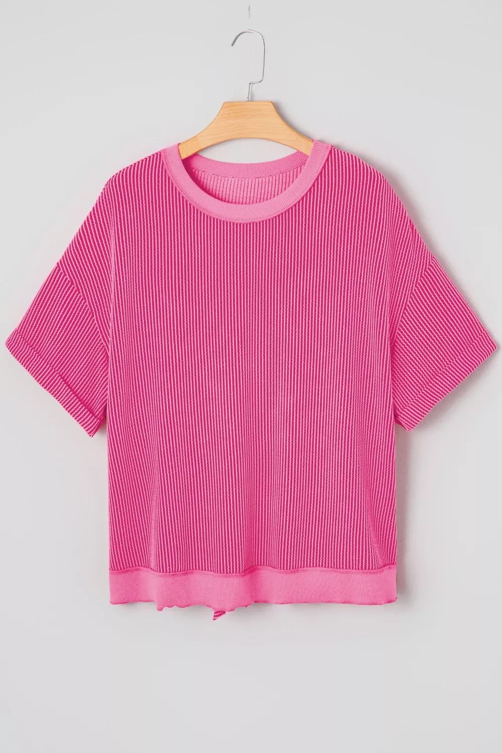 Pink ribbed maternity t-shirt with short sleeves, crew neck, and back bow detail.