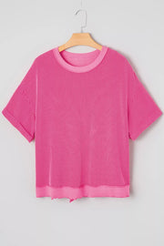Pink ribbed maternity t-shirt with short sleeves, crew neck, and back bow detail.