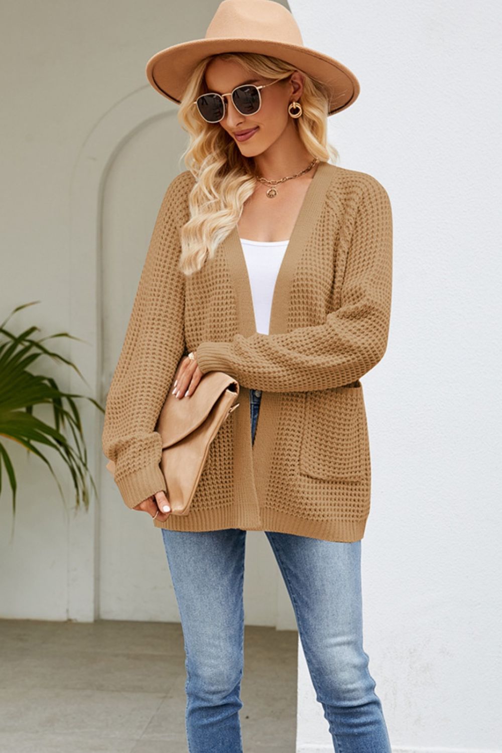 Khaki waffle knit cardigan with patch pockets and open front, styled with a white top and jeans.