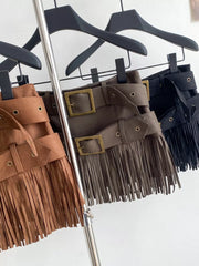 Tassel-trimmed belted mini skirts in brown and black with antique brass buckles.