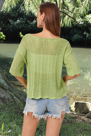 Light green open-knit top with scalloped sleeves and a boat neckline, styled with denim shorts.