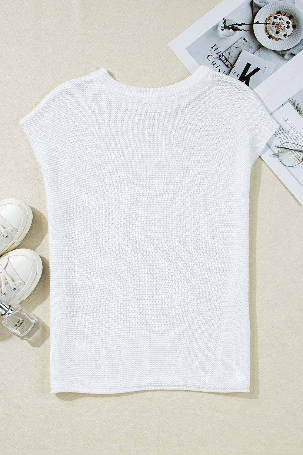 White boxy knit crop top with short sleeves and a crew neck.