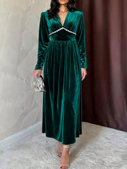 Green velvet maxi dress with ruched V-neck and long sleeves.