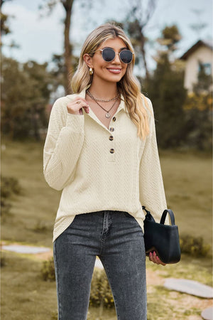Ivory textured knit polo shirt with button detail and long sleeves.