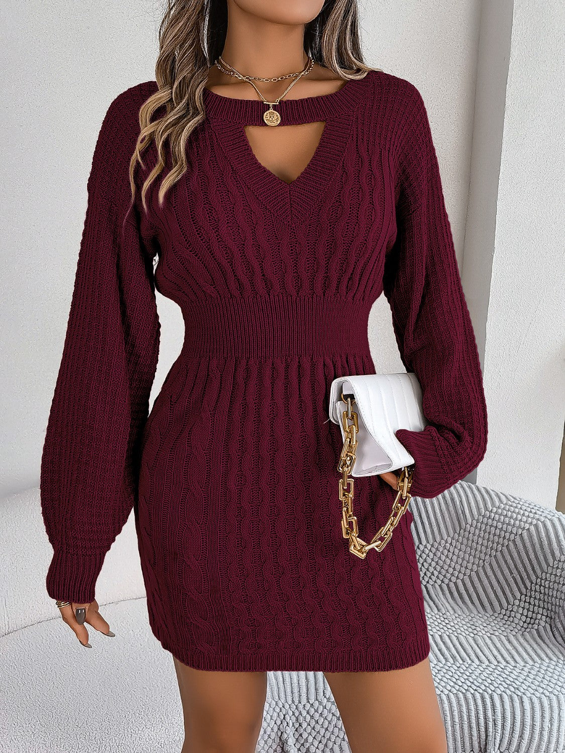 Wine cable knit mini dress with keyhole neckline and long balloon sleeves.