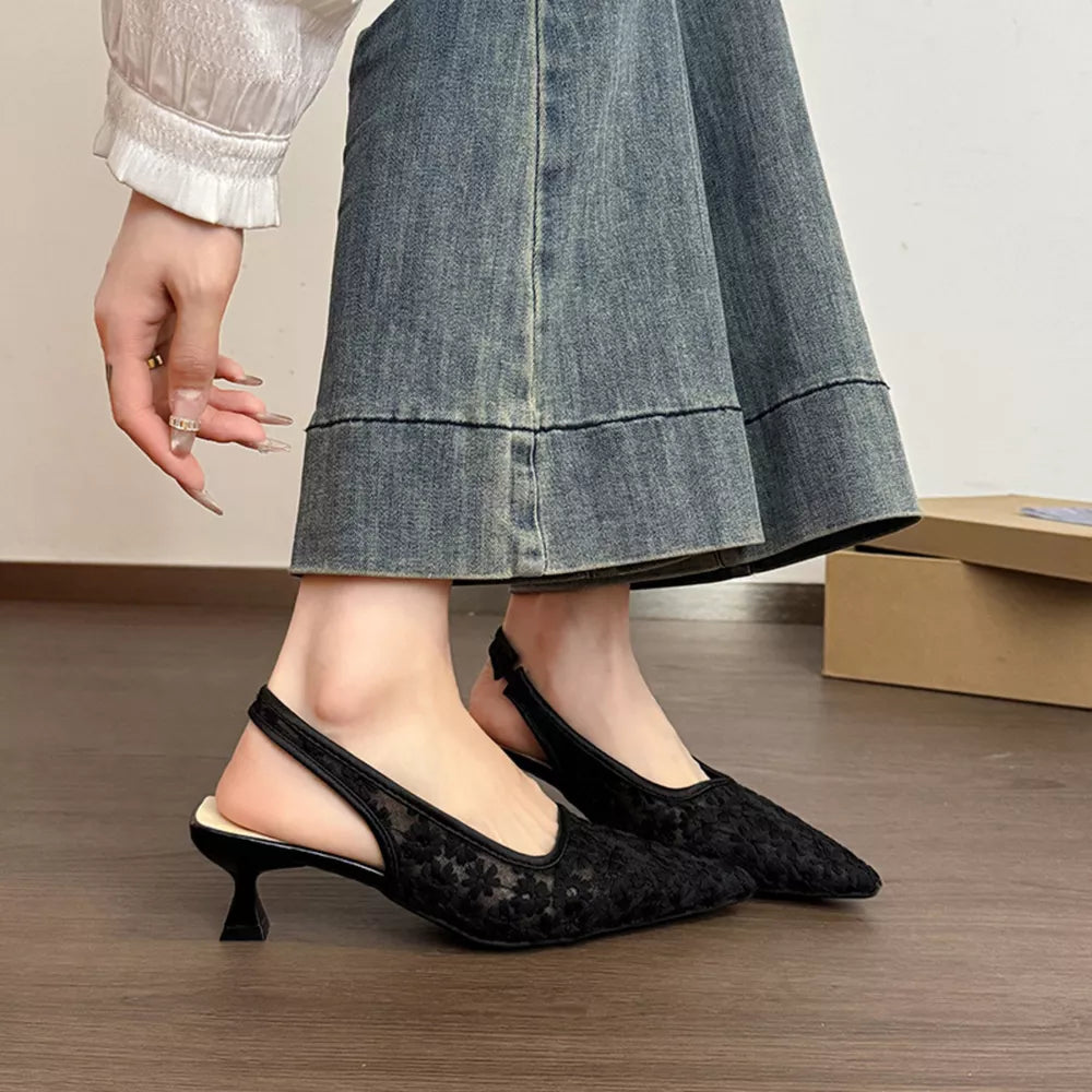 Black lace slingback kitten heels with a pointed toe and a kitten heel.