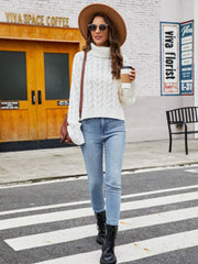 White cable-knit acrylic sweater with a high neck and long sleeves.