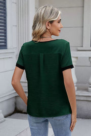 Dark green textured blouse with contrast trim and short sleeves.