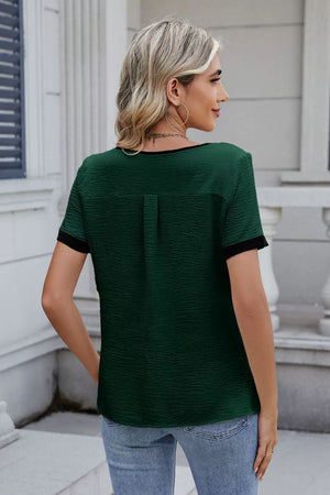 Dark green textured blouse with contrast trim and short sleeves.