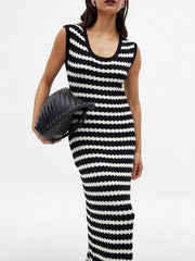 Striped scoop neck midi knit dress with side slit, held with a black woven clutch.
