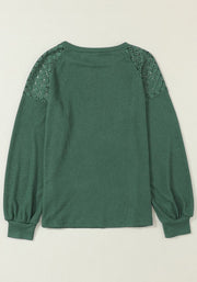 Green waffle knit raglan top with lace yoke and balloon sleeves.