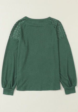 Green waffle knit raglan top with lace yoke and balloon sleeves.