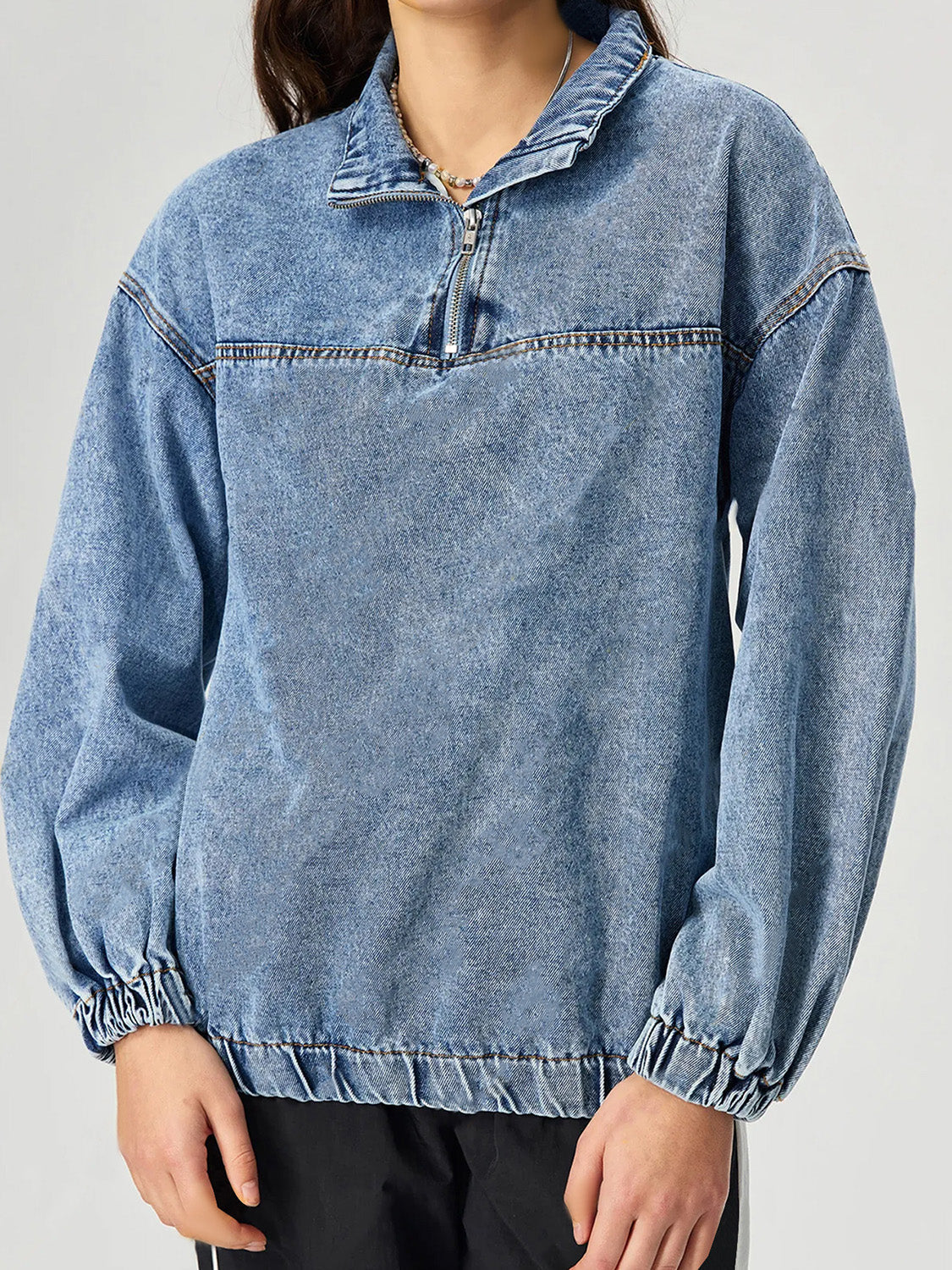 Acid wash denim pullover with quarter zip and elastic cuffs.