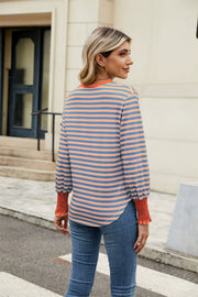 Striped long sleeve blouse with orange neckline and cuffs, blue and orange stripes