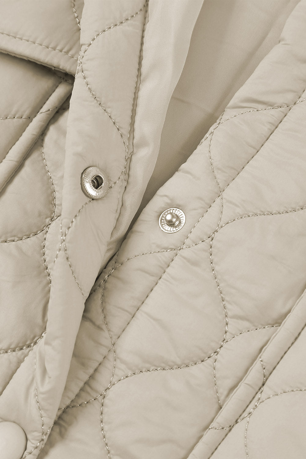 Camel quilted utility jacket with snap closures and metallic stitching detail.