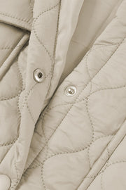 Camel quilted utility jacket with snap closures and metallic stitching detail.