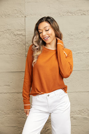 Caramel waffle knit raglan sweater with contrast stitching on cuffs and hem.