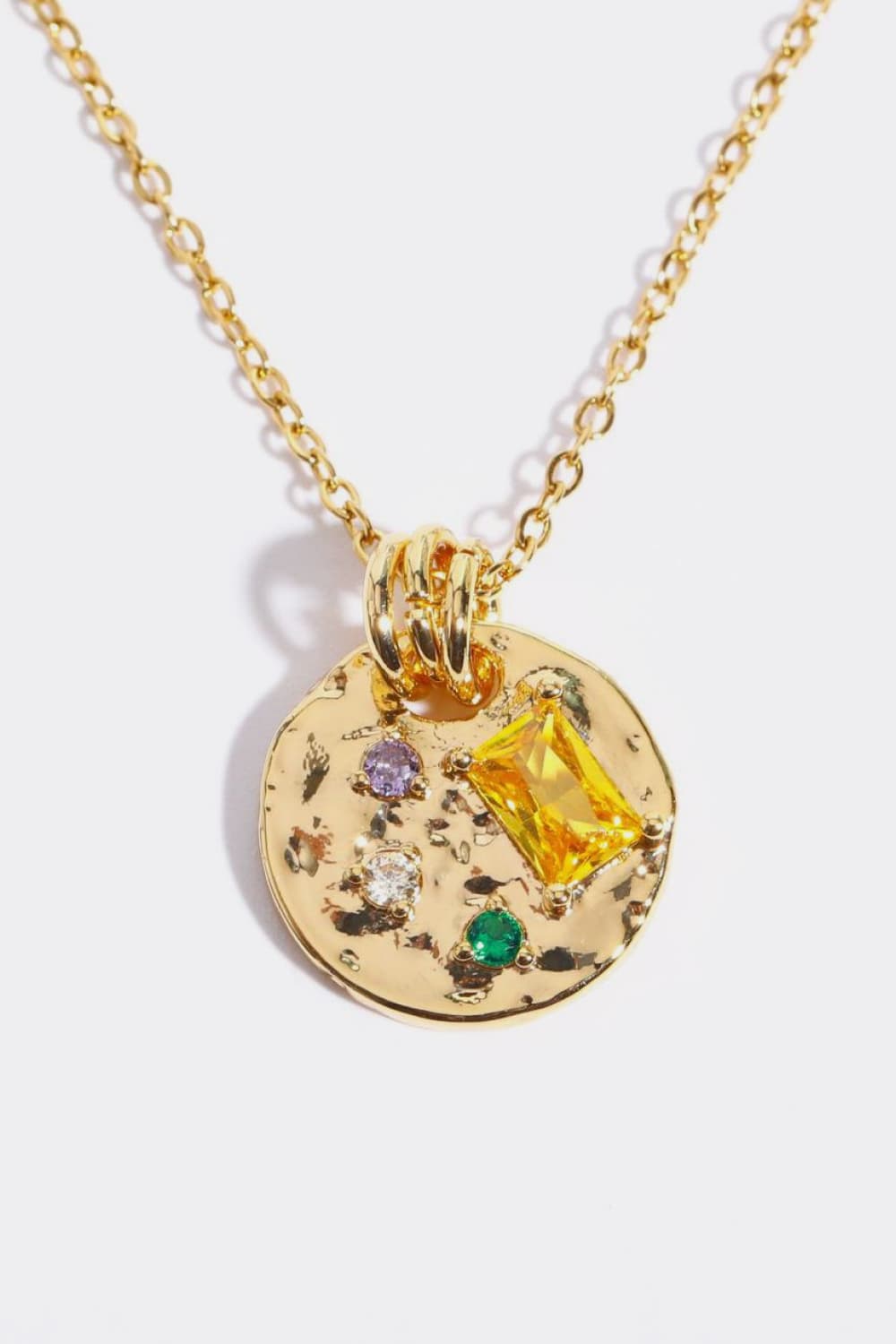 Gold textured disc pendant necklace with colorful gemstone accents