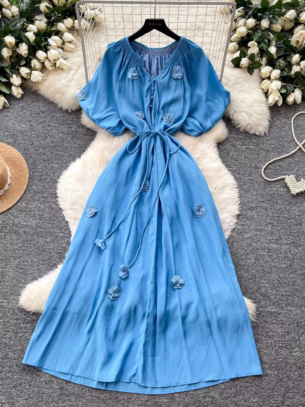 Blue floral maxi dress with puff sleeves, V-neck, tie waist and button front.