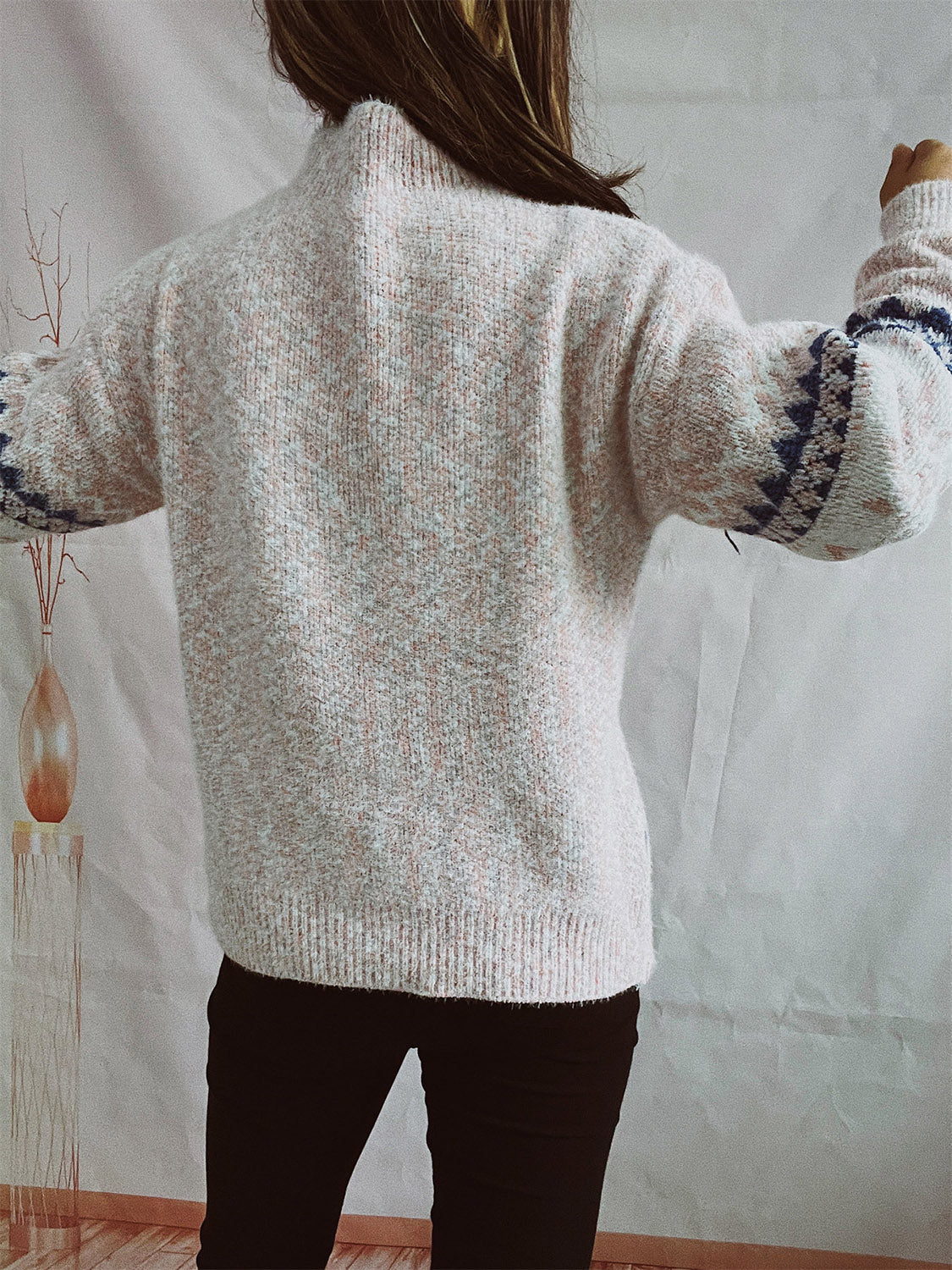Geometric knit mockneck pullover in speckled pastel yellow with blue geometric sleeve detail.