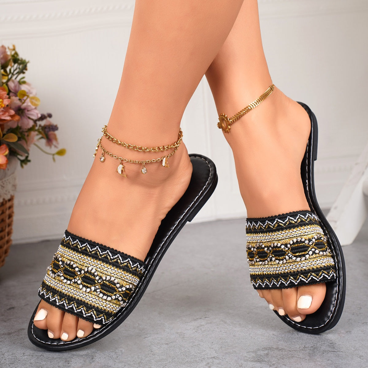 Black embroidered artisan open-toe slide sandals with bohemian detail.