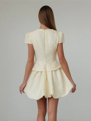 Textured cream tweed dress with short puff sleeves and bubble hem skirt.