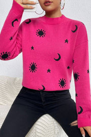 Hot pink acrylic knit sweater with black sun, moon, and star pattern, mock neck, long sleeves.