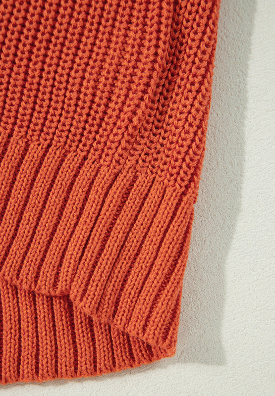 Orange acrylic knit sweater with ribbed texture and diagonal stitch detail.