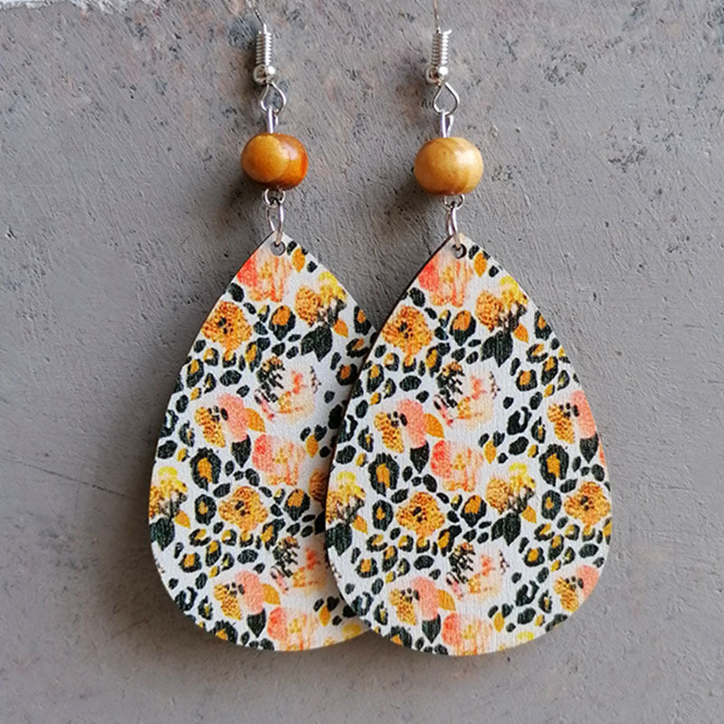 Teardrop earrings with floral and leopard print, wood beads, and silver hooks.