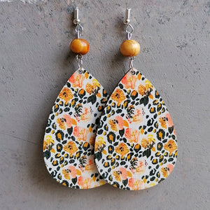 Teardrop earrings with floral and leopard print, wood beads, and silver hooks.