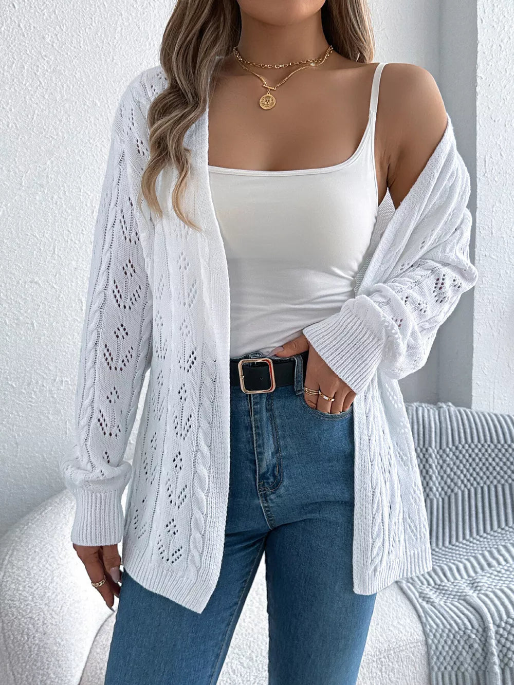 White openwork long sleeve acrylic cardigan with cable knit details.
