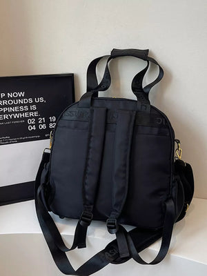 Black quilted Oxford bag with adjustable straps and top handle.