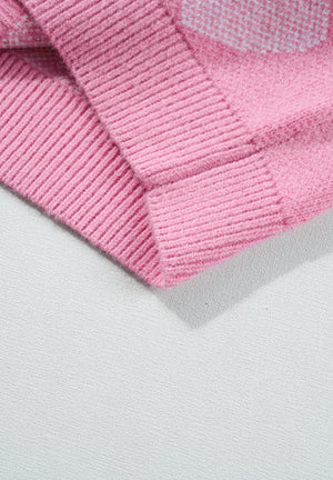Pink knit sweater with heart intarsia pattern and pearl embellishments.