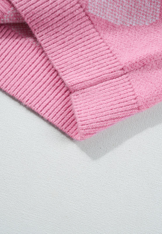 Pink knit sweater with heart intarsia pattern and pearl embellishments.