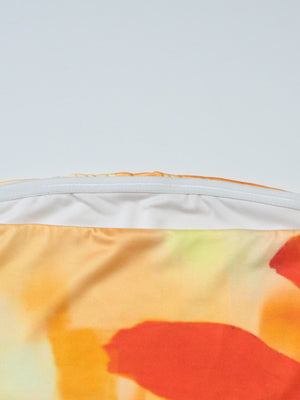 Floral print strapless tube top with orange and yellow abstract floral pattern and elastic band detail.