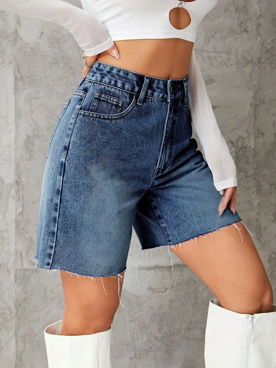 High-waisted denim bermuda shorts in medium blue wash with frayed hem.