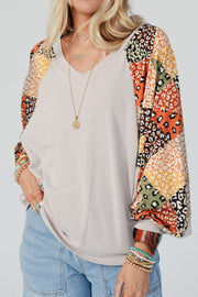Light gray v-neck top with patchwork raglan sleeves featuring animal prints.