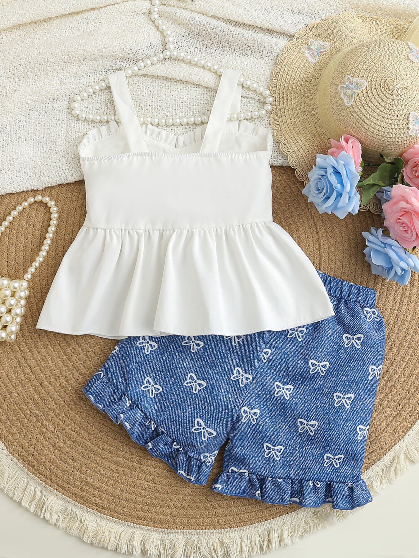 Baby girl white cami and blue bow print shorts set with ruffled hems.