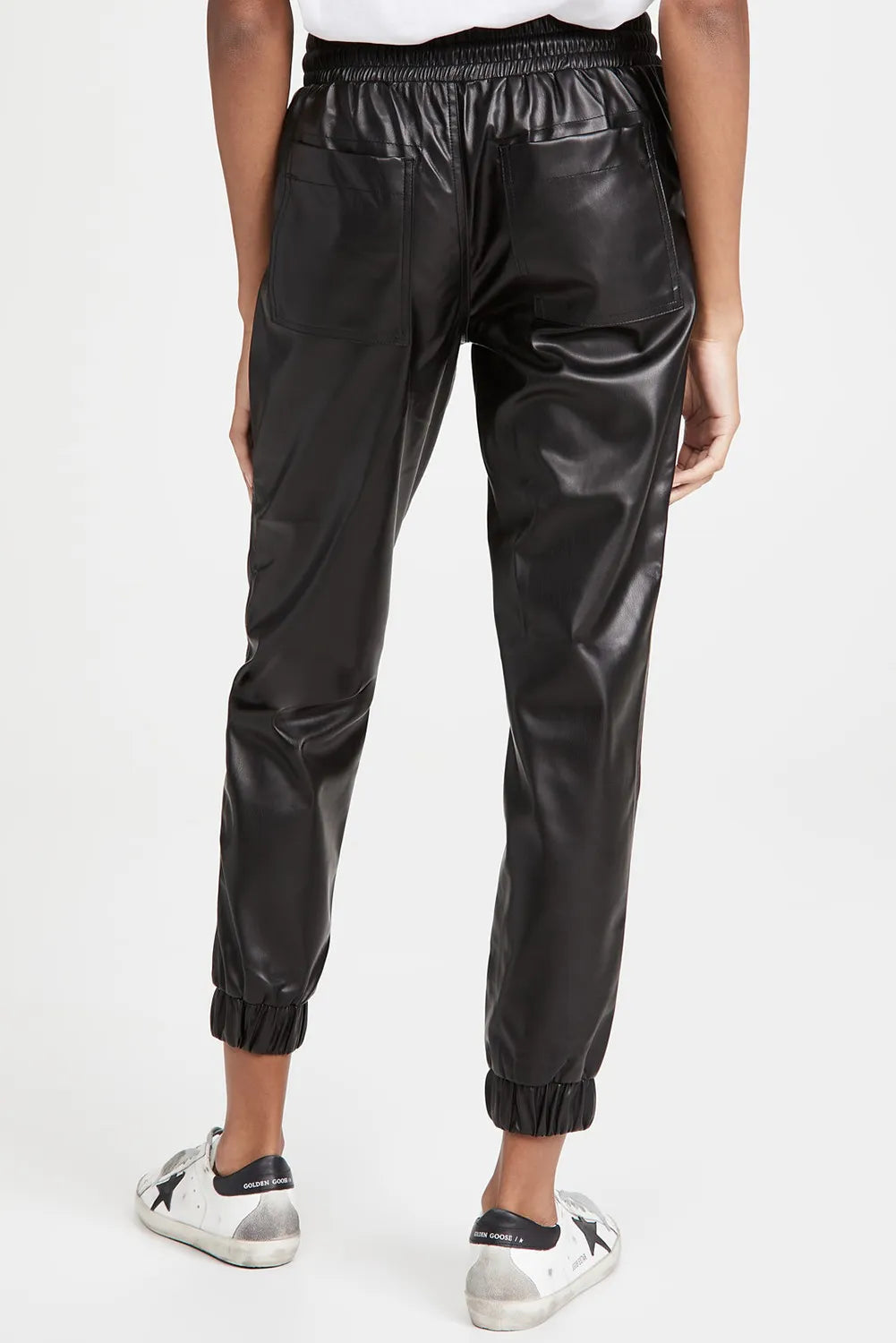 Black faux leather joggers with patch pockets and elastic cuffs.
