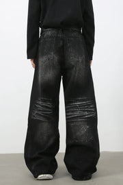 Faded black palazzo jeans with distressed denim and wide legs.