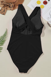 Black one-piece swimsuit with crisscross back detail and plunging neckline.