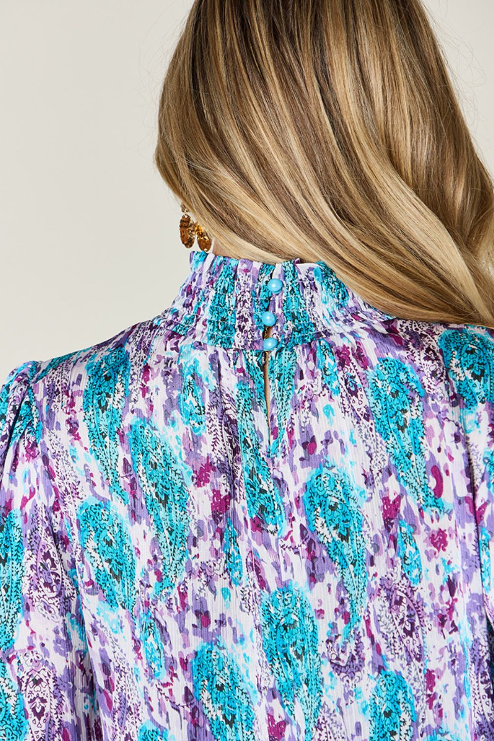 High neck abstract print blouse with smocked collar and button detail, in red-violet and sky blue.