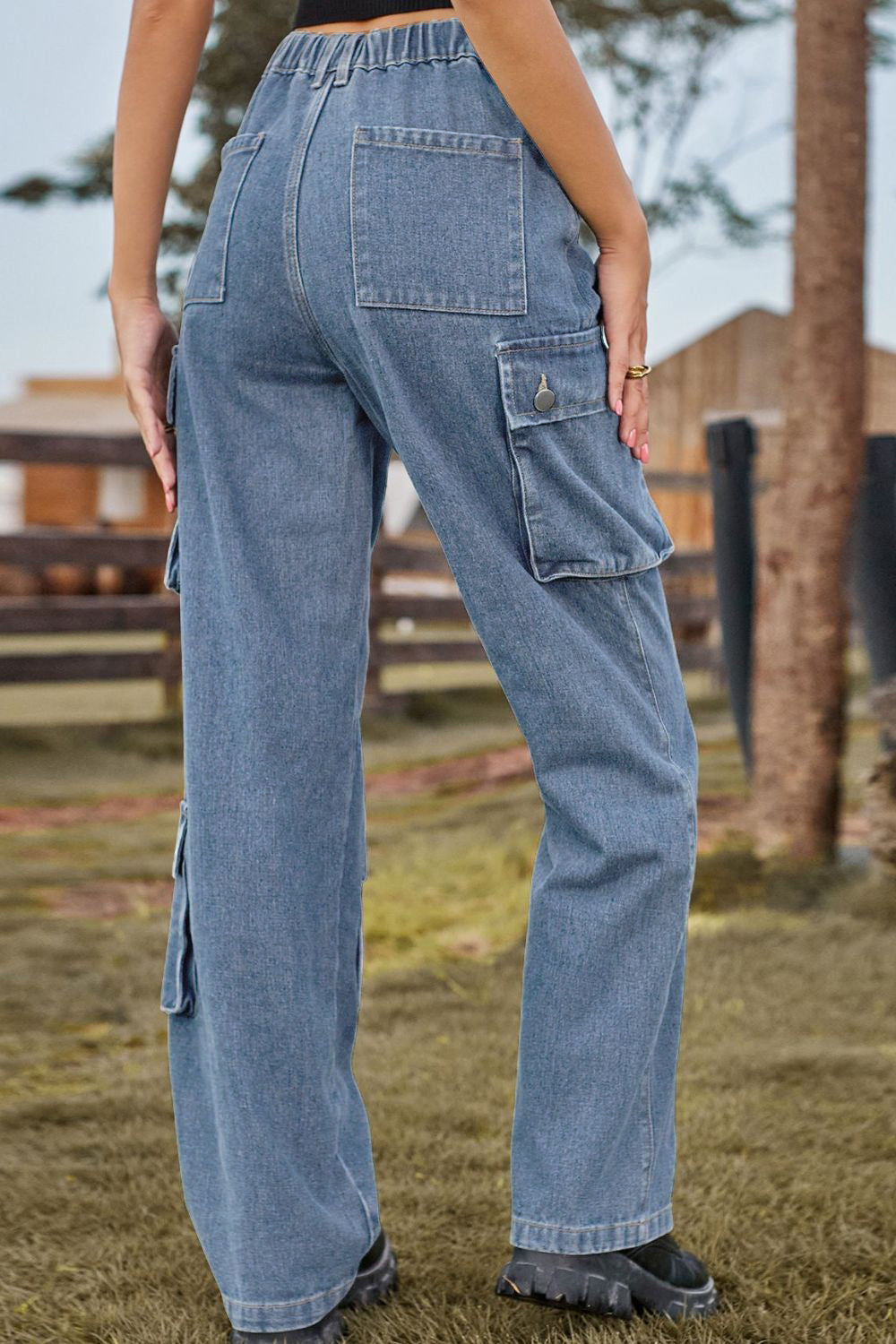 Denim cargo pants in light wash with relaxed wide leg and multiple utility pockets.